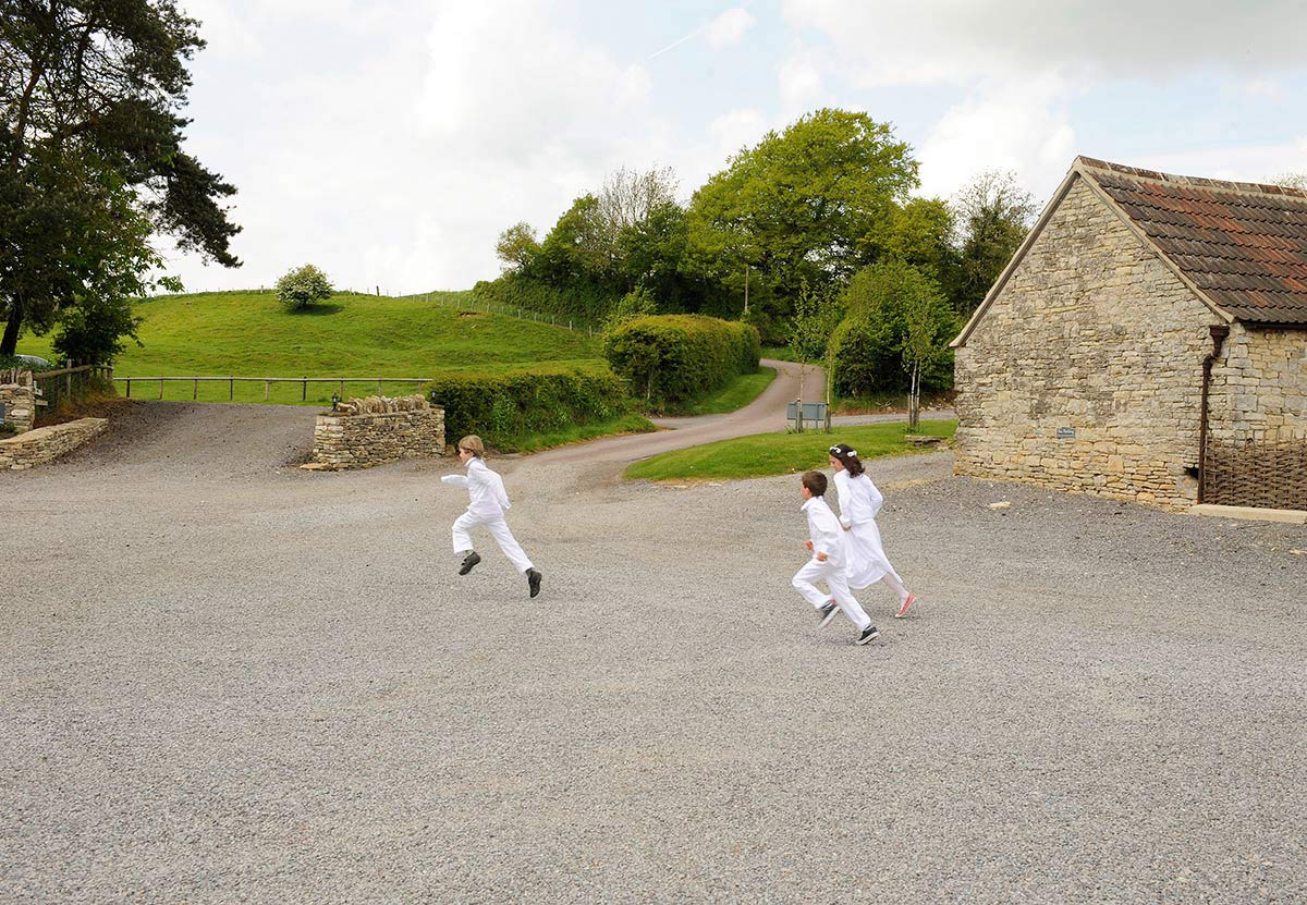 Honeylight Hochzeitsfotograf: Kinder spielen auf Gutshof