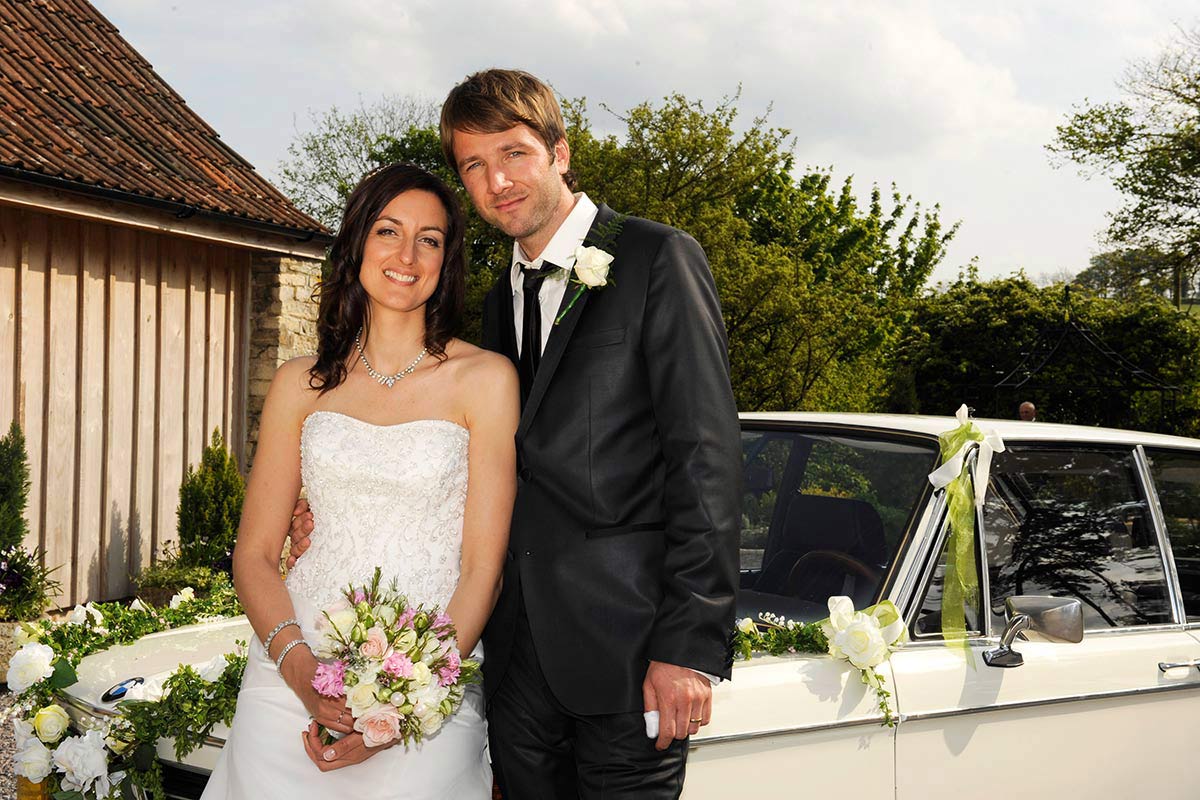 Honeylight Hochzeitsfotograf: Brautpaar vor BMW Hochzeitsauto