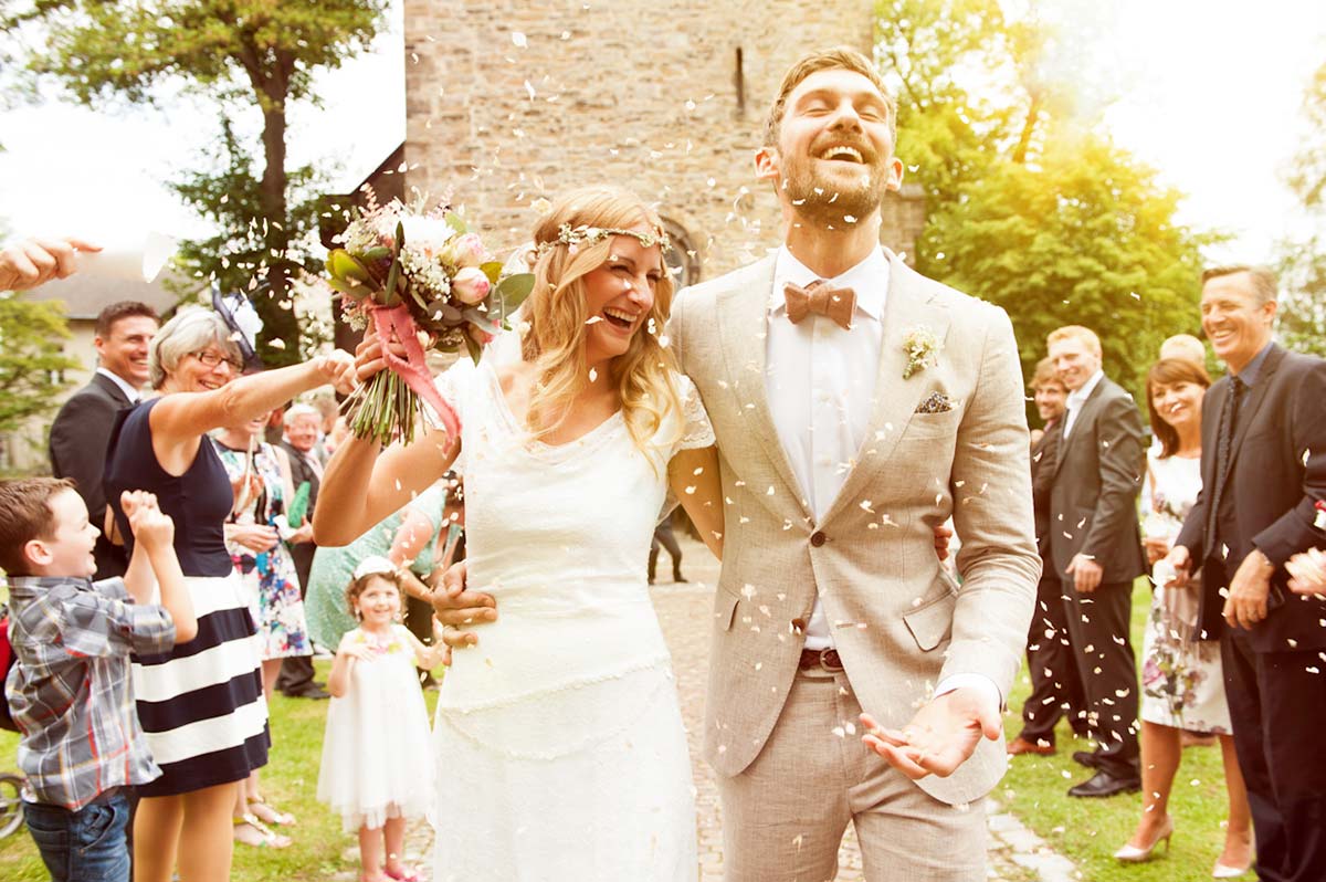 Honeylight Hochzeitsfotografen: Brautpaar kommt glücklich aus der Kirche