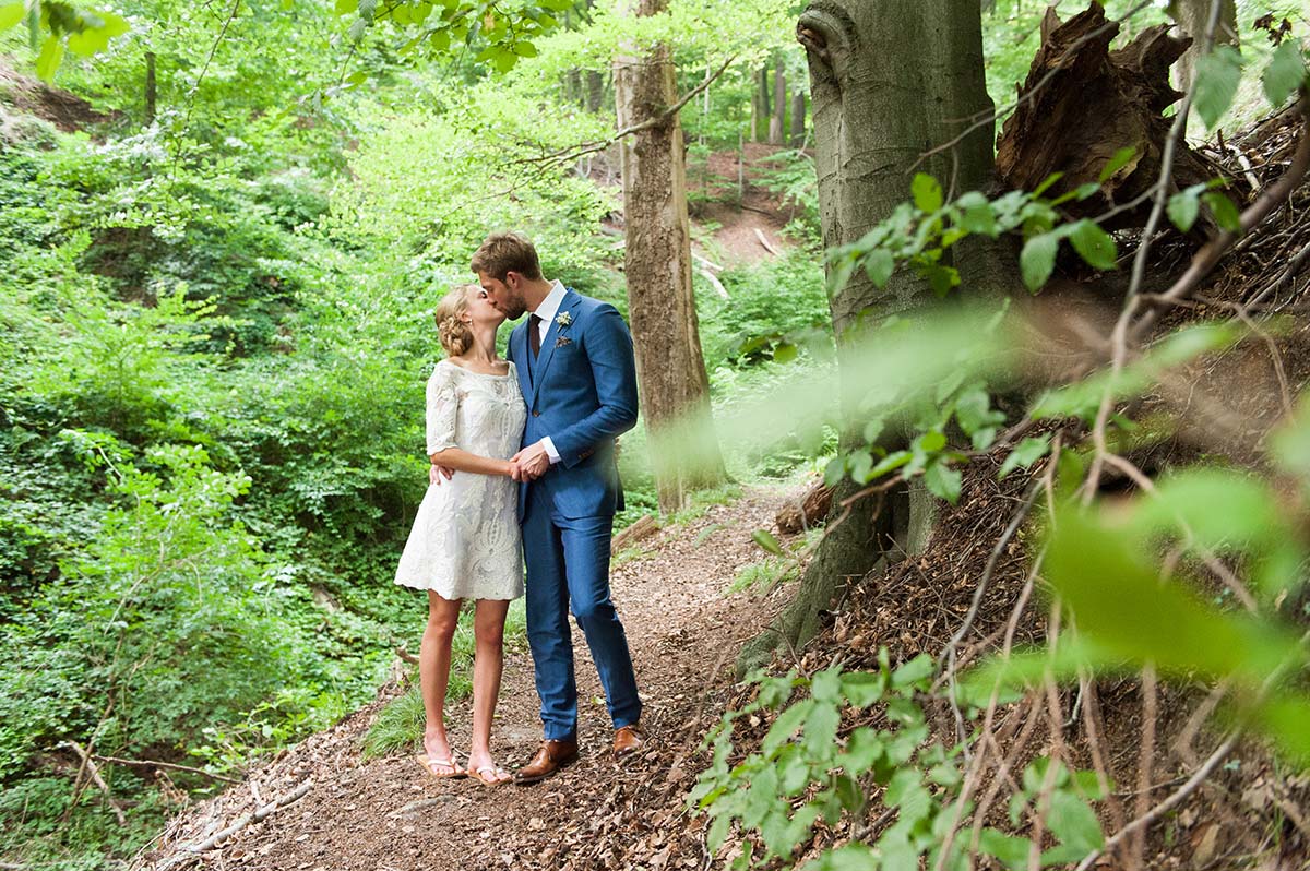 Honeylight Hochzeitsfotografen: Brautpaar küsst sich im Wald