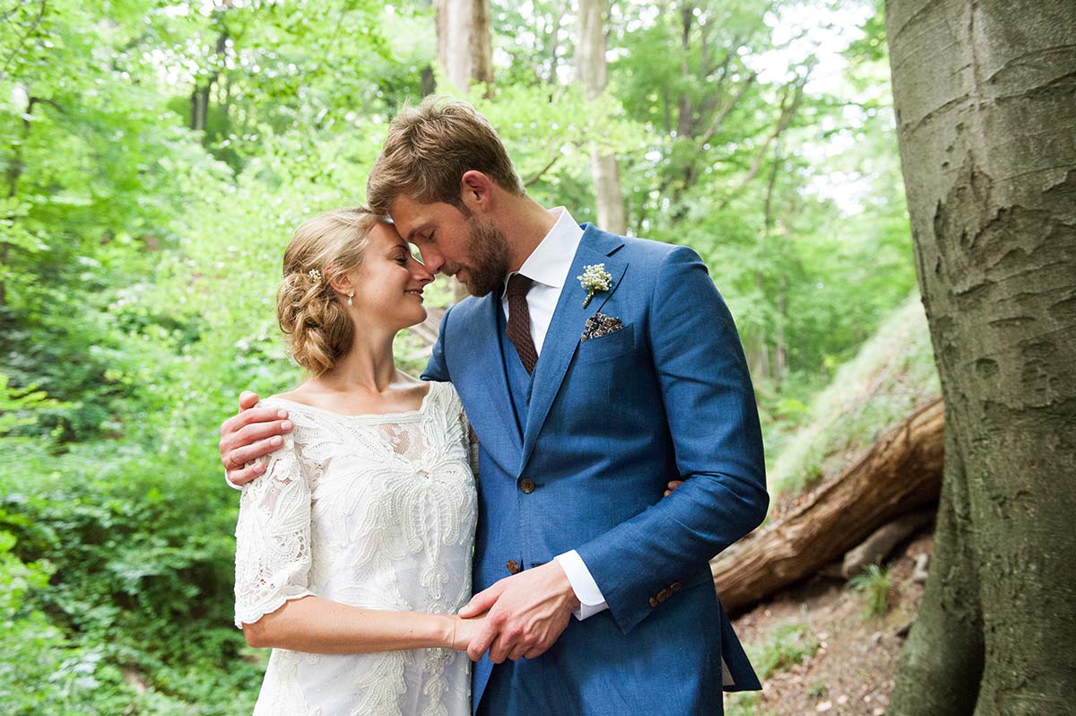 Honeylight Hochzeitsfotografen: Brautpaar schmust im Wald