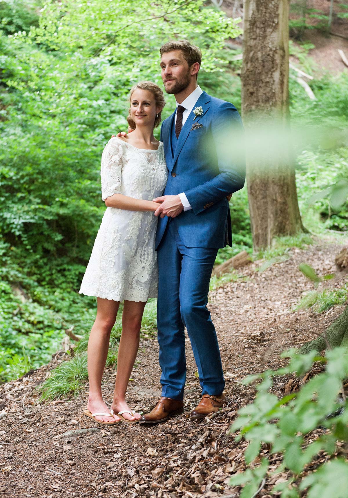 Honeylight Hochzeitsfotografen: Brautpaar steht im Wald und schaut in die Ferne