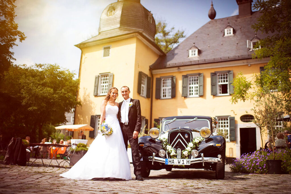 Hochzeitsfotografen Honeylight: Brautpaar steht der Location: Wuppertal Schloss Lüntenbeck